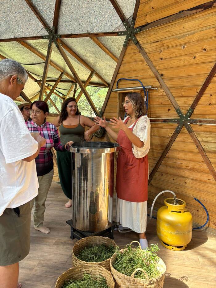 Grupo ao redor de um destilador artesanal de inox